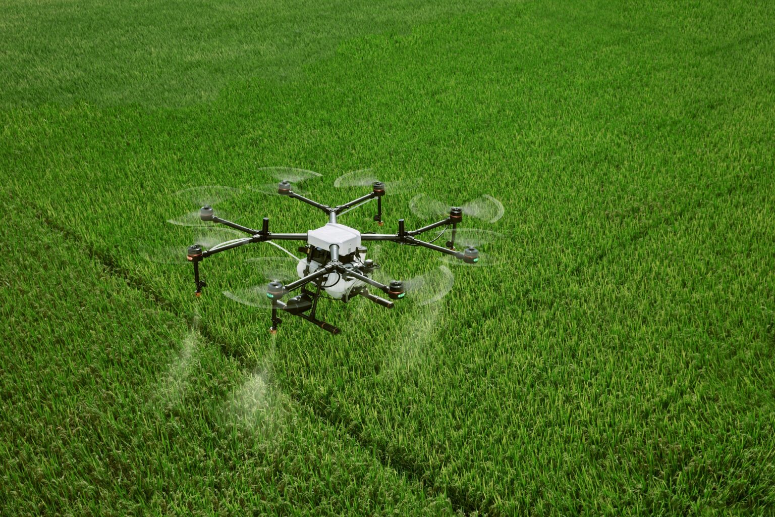 Drone agrícola pulverizador dispersando insumos em uma plantação